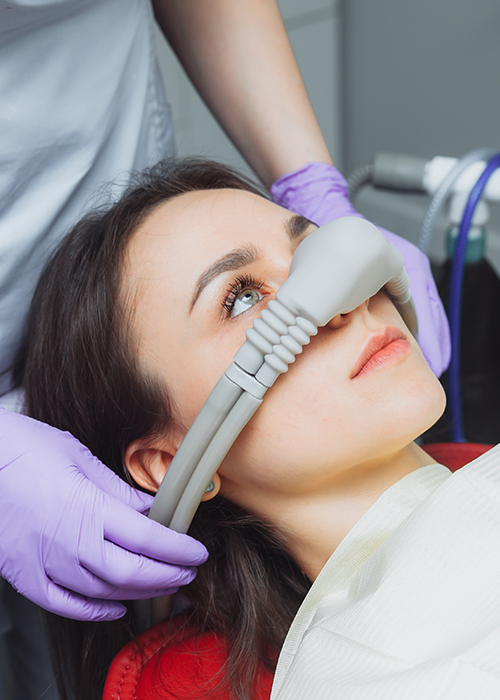 A woman at the dentist wearing a nasal mask for sedation or nitrous oxide.